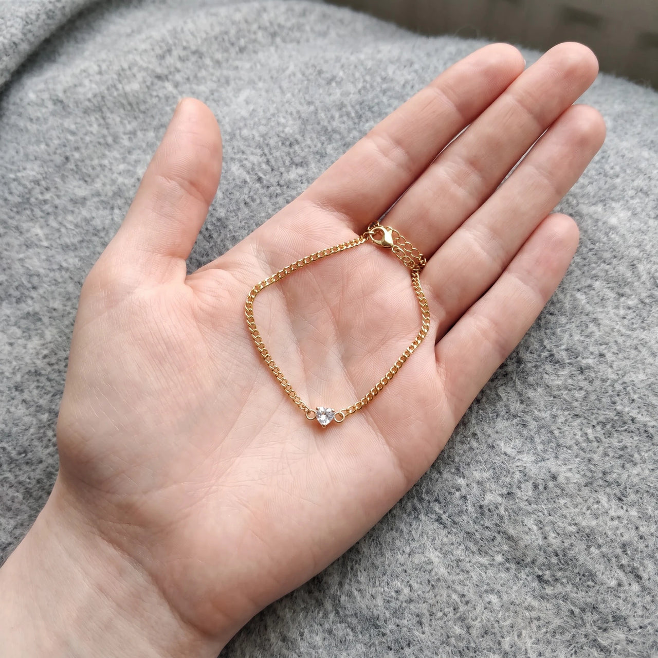 Heart Bond Matching Bracelet Set in Gold — her bracelet resting in an open palm